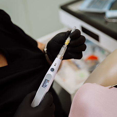 Dental professional holding a thin pen-like instrument