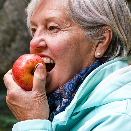 Older woman biting into an apple