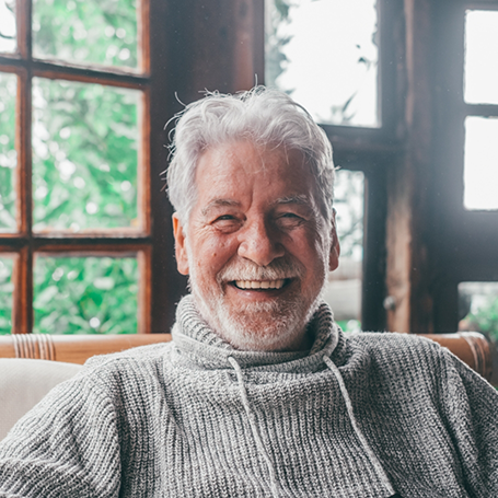 Smiling senior man in a gray sweater